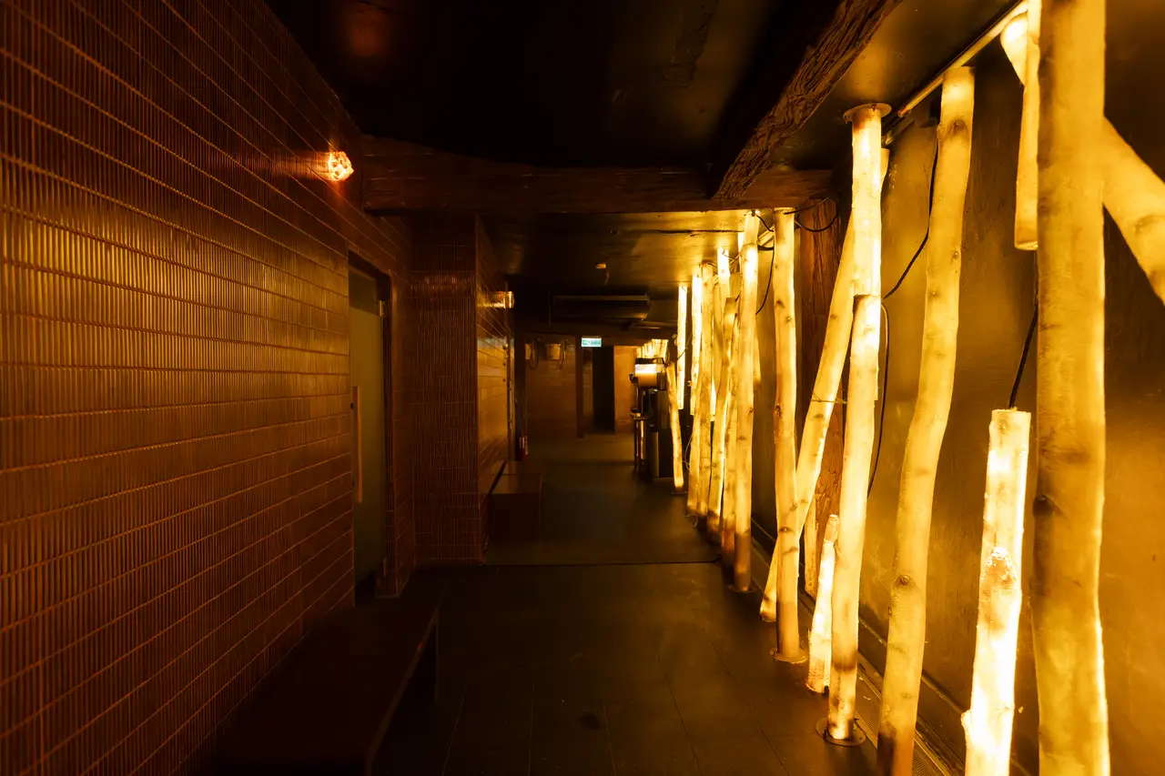 A warm corridor at Wellmax lit by glowing backlit columns, Bangkok
