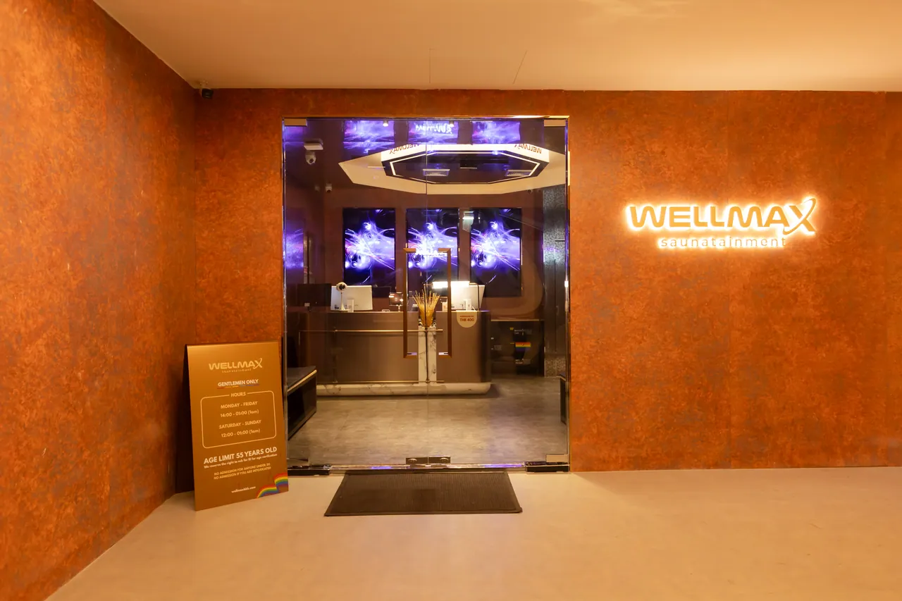 The entrance to Wellmax gay sauna — the illuminated WELLMAX sign above the turnstiles at B1, Wall Street Tower, Surawong, Bangkok